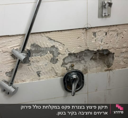 ברז מקלחת על קיר עם אריחים שבורים